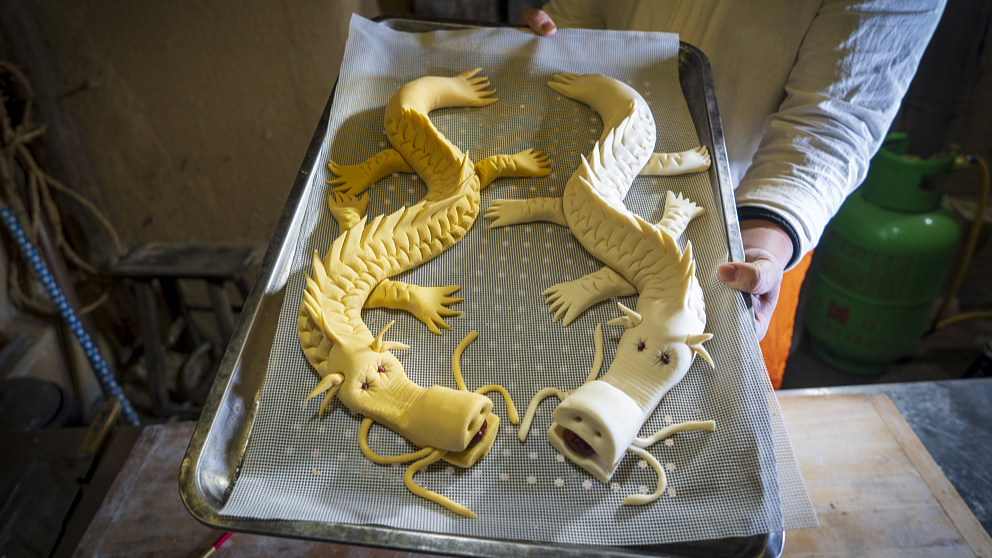 Melalui proses seperti fermentasi menguleni membentuk memotong sisik membuka mulut menambahkan mata dan membentuk kumis disertai dengan hiasan kacang merah kurma merah dan biji-bijian kasar lainnya serta buah-buahan kering