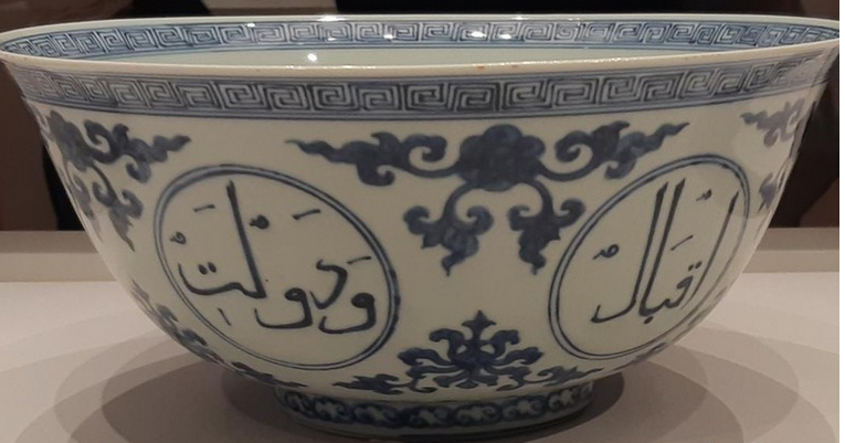 Mangkuk yang memiliki latar putih dengan kaligrafi biru ini