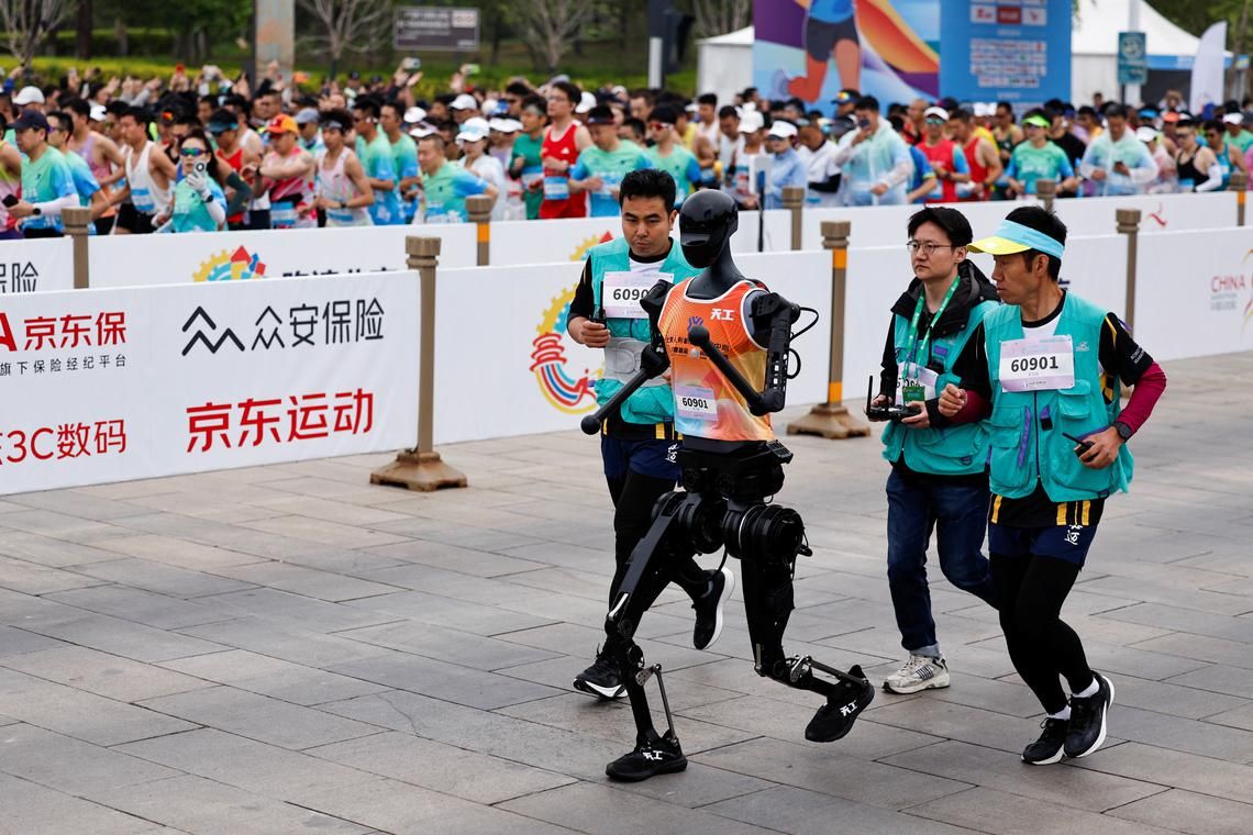 Banyak penonton membawa peralatan perekaman profesional untuk mengabadikan momen lomba lari setengah maraton robot pertama di dunia
