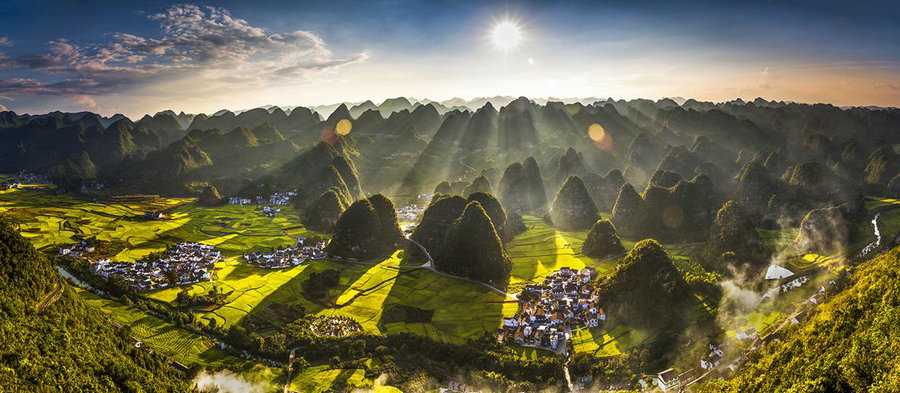 Jika anda berada di Xingyi kota tingkat kabupaten di prefektur otonom Qianxinan Buyei dan Miao di barat daya provinsi Guizhou anda dapat melihat siluet aliran puncak hijau yang diselimuti selubung kabut tipis yang mengalir menawarkan pemandangan unik dari Hutan Wanfeng