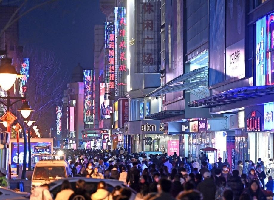 Orang-orang menikmati waktu luang mereka di kawasan komersial di tianjin Tiongkok utara